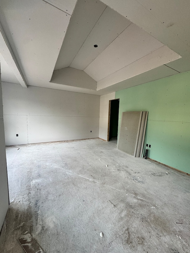 unfurnished room featuring lofted ceiling