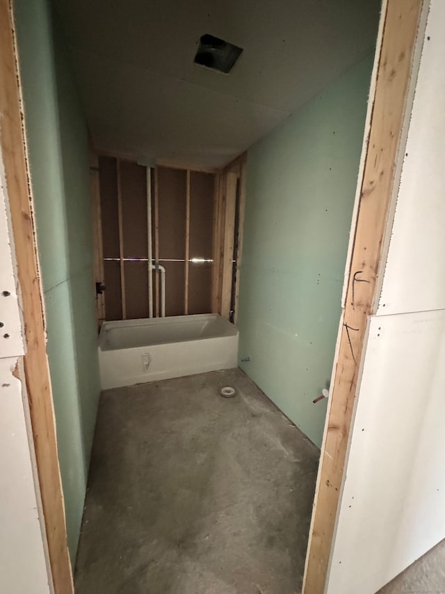 bathroom featuring concrete flooring and a tub