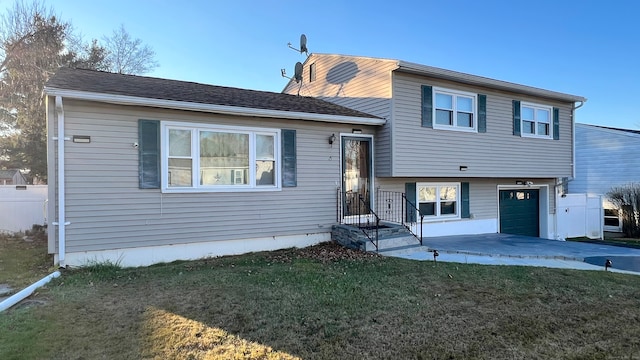 split level home featuring a garage and a front lawn