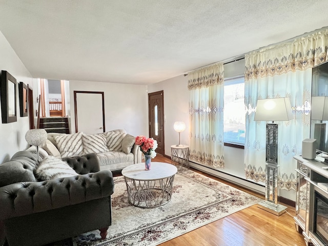 living room with a textured ceiling, wood-type flooring, and baseboard heating