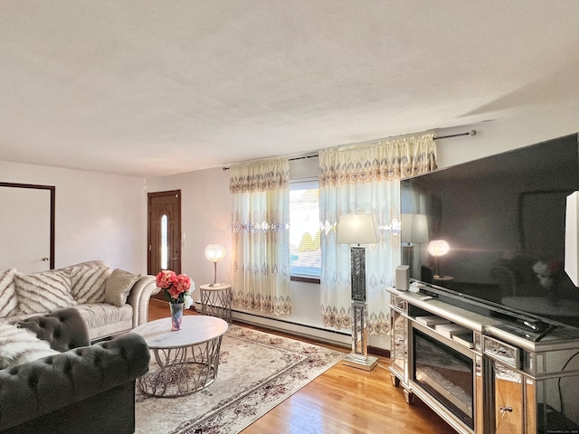 living room with a textured ceiling, light wood-type flooring, and baseboard heating