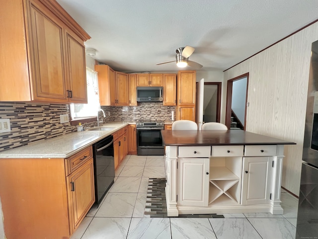 kitchen featuring backsplash, sink, ceiling fan, appliances with stainless steel finishes, and a kitchen island