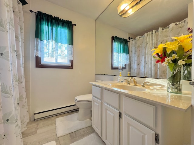 bathroom with vanity, a baseboard radiator, toilet, and a healthy amount of sunlight