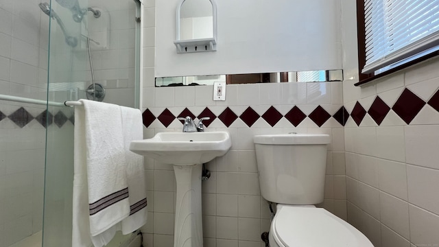 bathroom featuring walk in shower, toilet, and tile walls