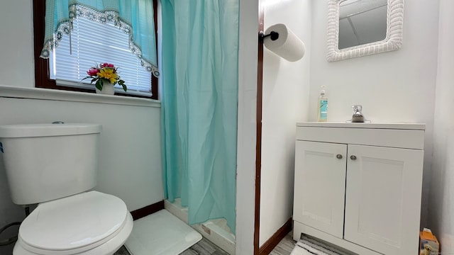 bathroom featuring vanity, toilet, and curtained shower