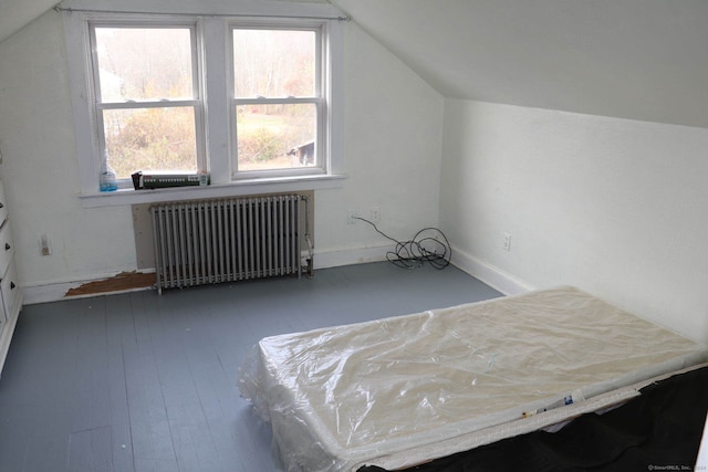 interior space with radiator heating unit, vaulted ceiling, and wood-type flooring