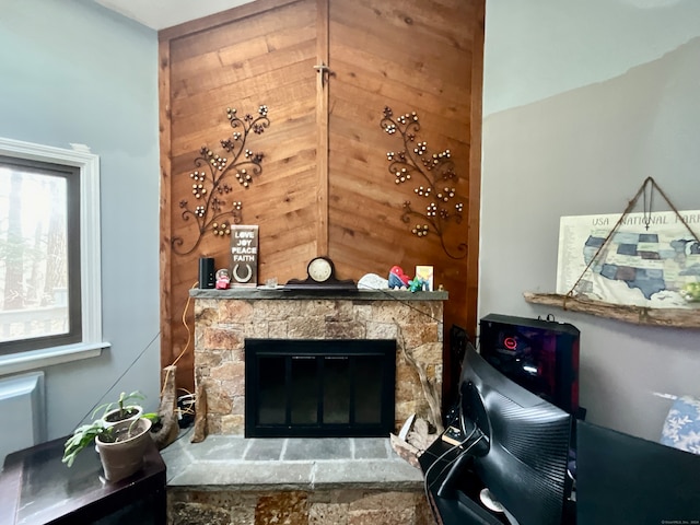 interior space with a stone fireplace and wooden walls