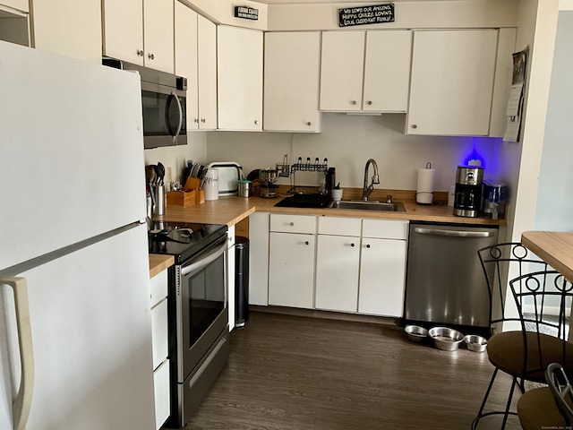 kitchen with stainless steel appliances, dark hardwood / wood-style floors, white cabinetry, and sink