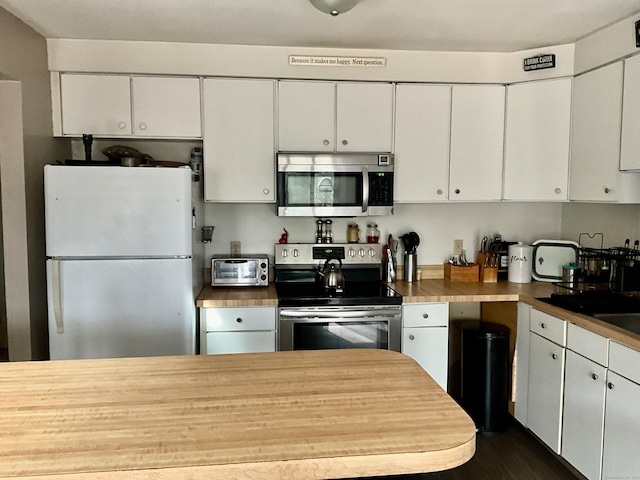 kitchen with white cabinets, stainless steel appliances, and dark wood-type flooring