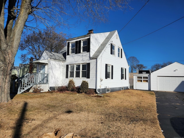 view of front of house with a garage, an outdoor structure, and a front lawn