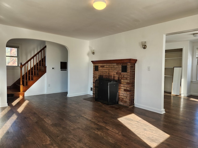 unfurnished living room featuring dark hardwood / wood-style flooring and a fireplace