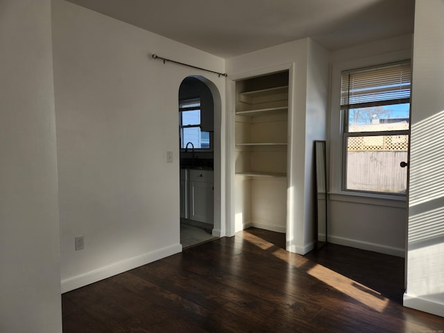 spare room with sink and dark wood-type flooring