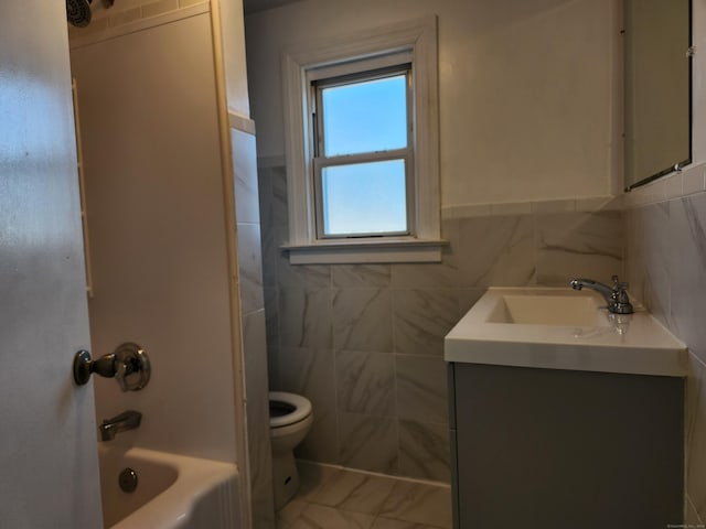 full bathroom featuring vanity, toilet, washtub / shower combination, and tile walls