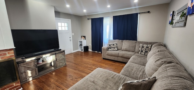 living room with hardwood / wood-style floors and a brick fireplace