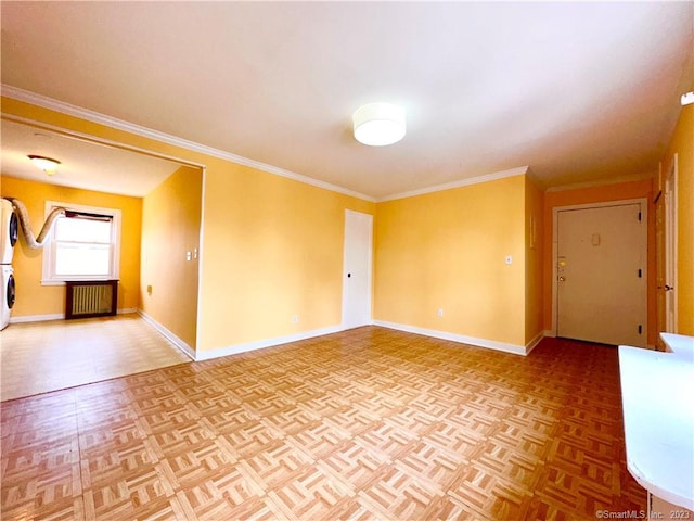 unfurnished room with radiator, stacked washer and clothes dryer, parquet flooring, and crown molding