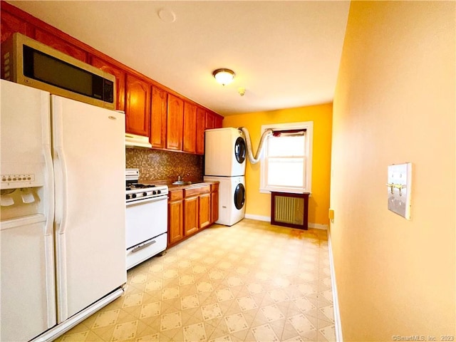 kitchen with stacked washing maching and dryer, tasteful backsplash, and white appliances