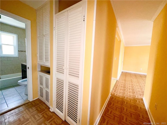 hall with parquet flooring and crown molding