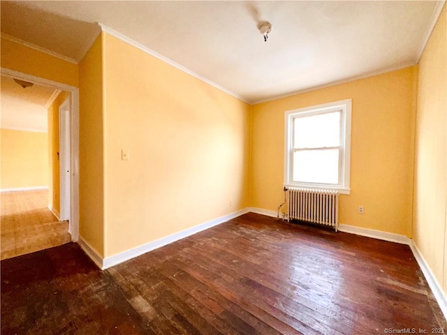 spare room featuring ornamental molding, radiator heating unit, and dark wood-type flooring