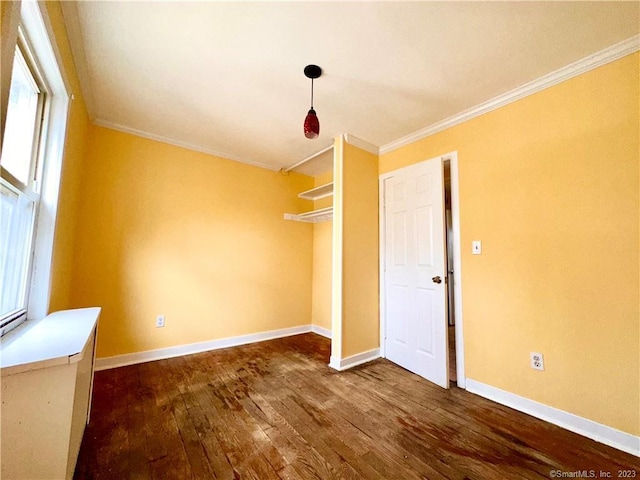 unfurnished bedroom featuring dark hardwood / wood-style flooring, a closet, and ornamental molding