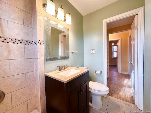 bathroom with vanity, parquet flooring, and toilet