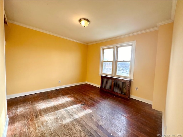 empty room with dark hardwood / wood-style floors and ornamental molding