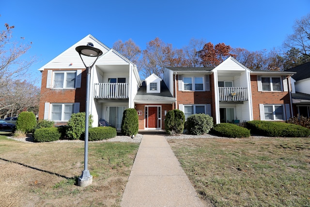 multi unit property featuring a front yard and a balcony