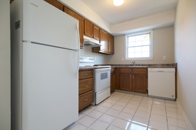 kitchen featuring light tile patterned floors, white appliances, and sink