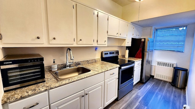 kitchen featuring radiator, white cabinets, sink, dark hardwood / wood-style floors, and appliances with stainless steel finishes