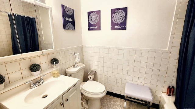 bathroom featuring vanity and tile walls