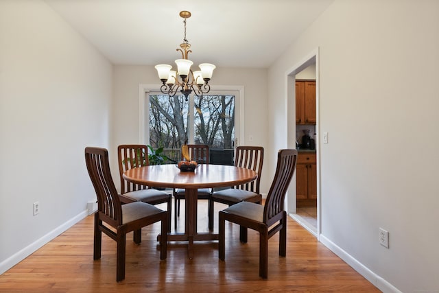 dining room featuring wood-type flooring and an inviting chandelier