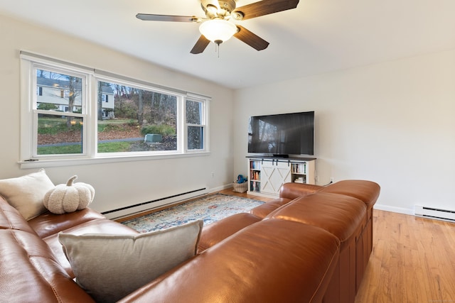 living room with a baseboard radiator, ceiling fan, and light hardwood / wood-style flooring