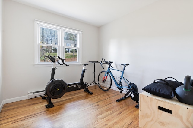 workout area with a baseboard radiator and light hardwood / wood-style flooring