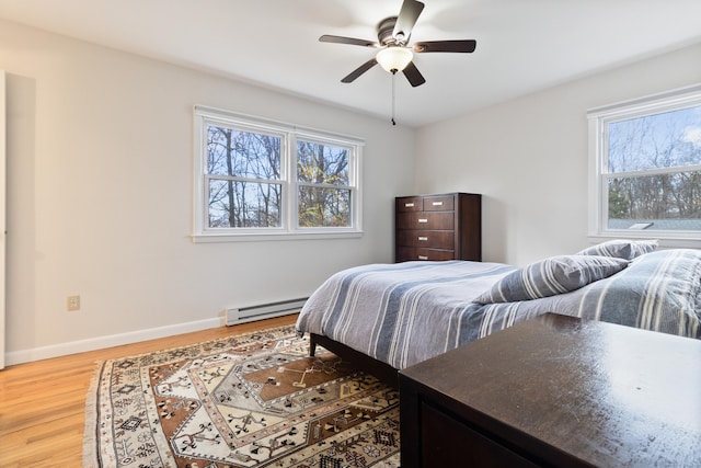 bedroom featuring hardwood / wood-style flooring, a baseboard radiator, and ceiling fan