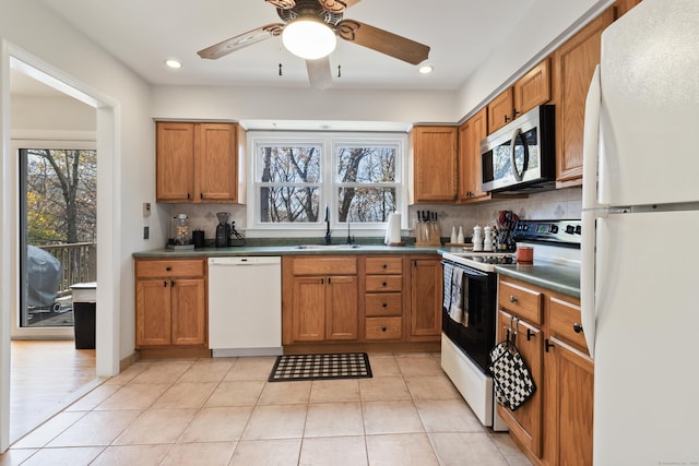 kitchen with sink, white appliances, light tile patterned floors, and backsplash