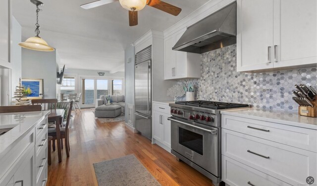 442 Seaside Ave, Westbrook, CT 06498 - kitchen featuring high end appliances, wall chimney exhaust hood, a ceiling fan, light countertops, and light wood finished floors