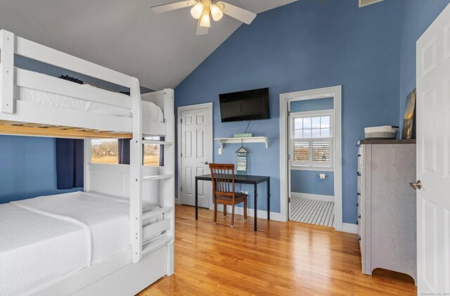 bedroom with light hardwood / wood-style floors, high vaulted ceiling, and ceiling fan