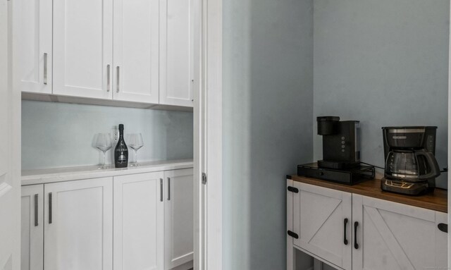 bar with white cabinets and wooden counters