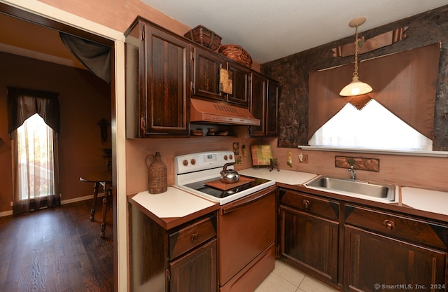 kitchen featuring light hardwood / wood-style floors, sink, custom exhaust hood, electric range, and decorative light fixtures