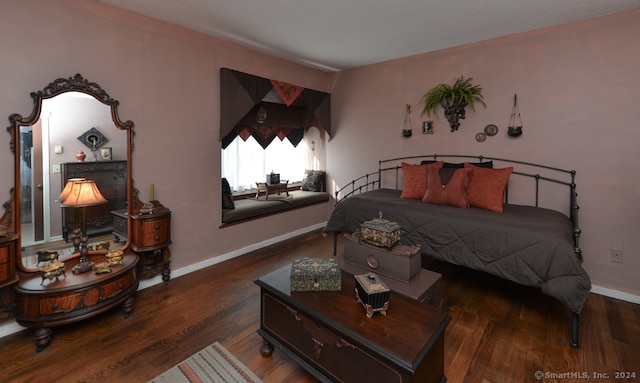 bedroom with dark hardwood / wood-style flooring