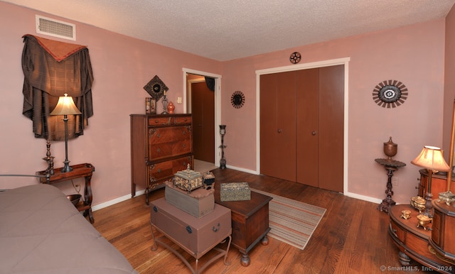 living room featuring dark hardwood / wood-style flooring and a textured ceiling