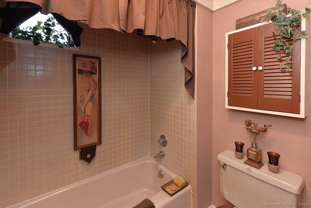 bathroom with tiled shower / bath and toilet