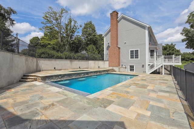 view of swimming pool featuring a wooden deck and a patio