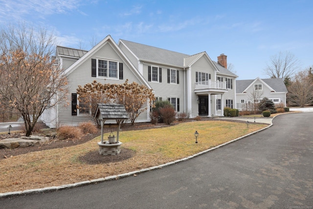 view of front of home featuring a balcony and a front yard