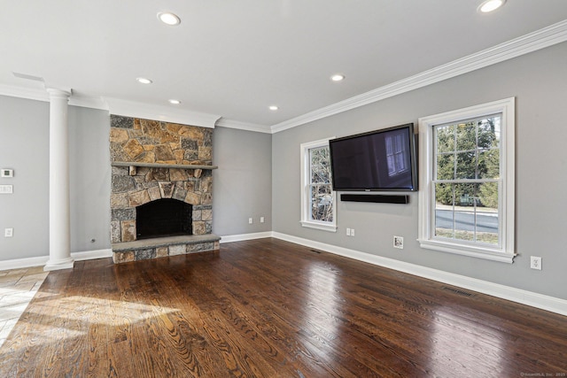 unfurnished living room featuring ornate columns, crown molding, a fireplace, and wood-type flooring