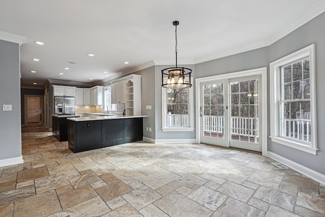 kitchen featuring a notable chandelier, hanging light fixtures, ornamental molding, white cabinets, and stainless steel fridge