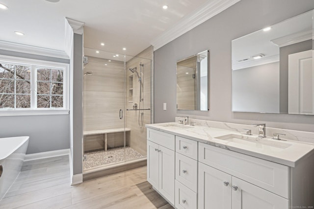 bathroom with wood-type flooring, crown molding, separate shower and tub, and vanity