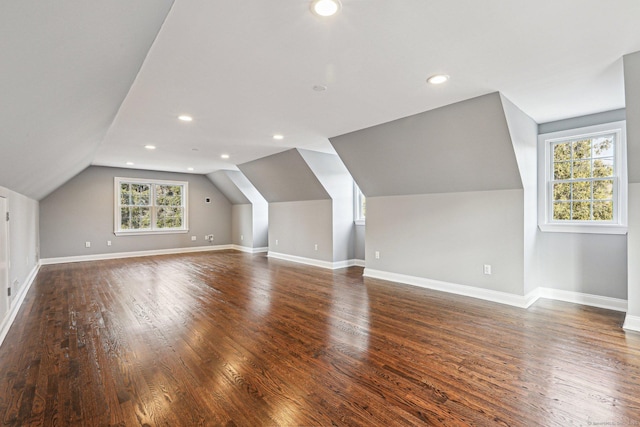 additional living space with plenty of natural light, dark hardwood / wood-style flooring, and vaulted ceiling