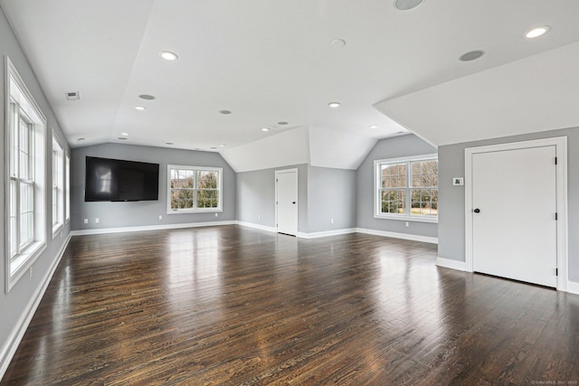 unfurnished living room featuring lofted ceiling, a healthy amount of sunlight, and dark hardwood / wood-style flooring