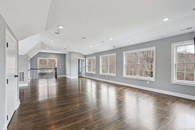 unfurnished living room with vaulted ceiling and dark wood-type flooring