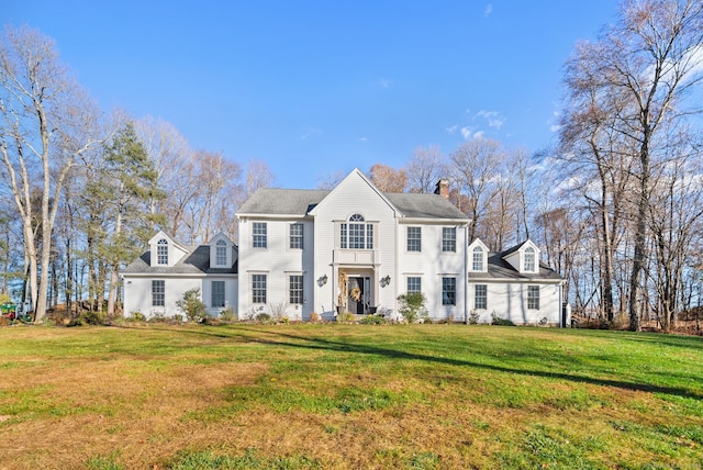 colonial home featuring a front lawn